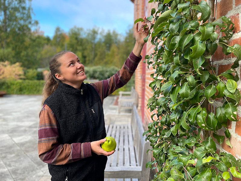 Tjej står i trädgård