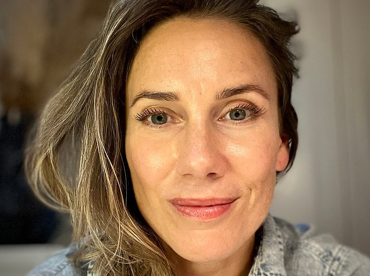 Porträtt på kvinna med långt hår och bruna ögon som tittar in i kameran.