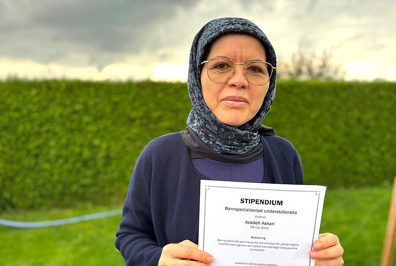 Kvinna håller upp diplom