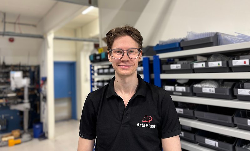 Porträttbild på man som står i fabrik